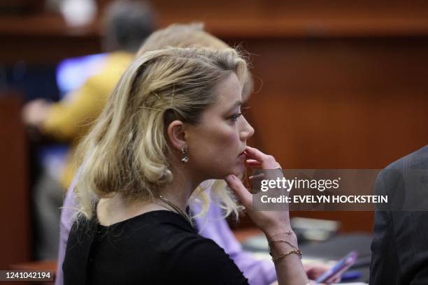 Actress Amber Heard waits before the jury said that they believe she defamed ex-husband Johnny Depp, while announcing split verdicts in favor of both...