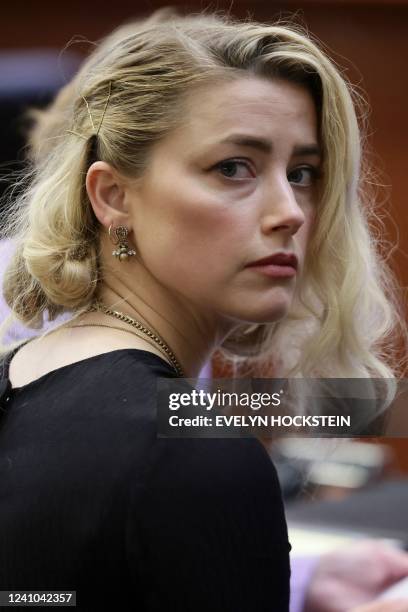 Actor Amber Heard waits before the jury said that they believe she defamed ex-husband Johnny Depp while announcing split verdicts in favor of both...