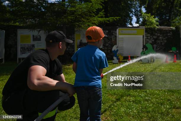 Member of the local fire department demonstrates to a young child how to use a fire hydrant to stop a fire. The Augustinian Sisters and the Pauline...