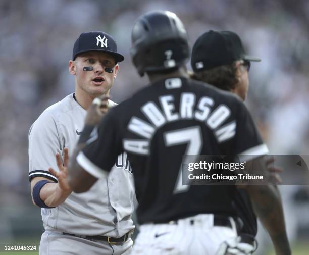 New York Yankees third baseman Josh Donaldson, left, and Chicago White Sox baserunner Tim Anderson, right, share words at third base in the first...