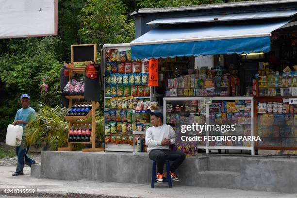 Kiosk seller waits for customer at Cafetal neighborhood in Caracas on June 1, 2022. - They are light years away from the good old days, but US...