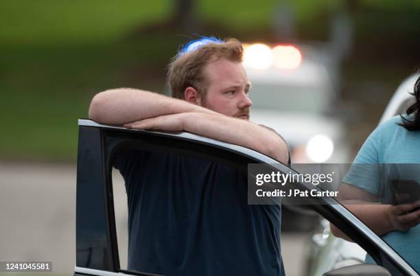 Man waits by his car as police respond to a mass shooting at St. Francis Hospital on June 1, 2022 in Tulsa, Oklahoma. At least four people were...