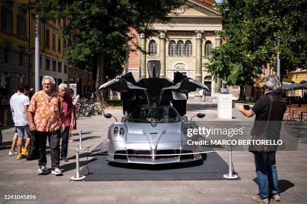 People take pictures and visit the stand of Italian sports car manufacturer Pagani at Piazza Mazzini in Modena, Northern Italy, during the Motor...