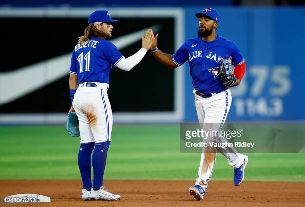 Teoscar Hernandez of the Toronto Blue Jays high fives Bo Bichette following a 7-3 win over the Chicago White Sox at Rogers Centre on June 01, 2022 in...