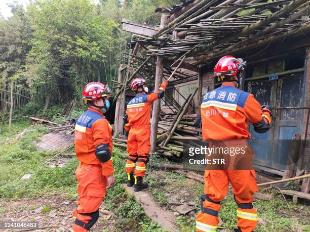 Recuers check houses damaged in a 6.1-magnitude earthquake which killed four people and injured 14 others in Yaan, in China's southwestern Sichuan...