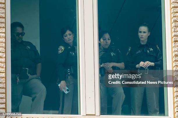Fairfax County sheriffs look down from a window and wait for the departure of Actress Amber Heard from the Fairfax County Courthouse on June 1, 2022...