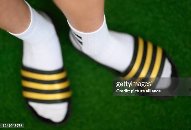 May 2022, Saxony, Dresden: ILLUSTRATION - A boy wears adilettes and tennis socks. Photo: Robert Michael/dpa