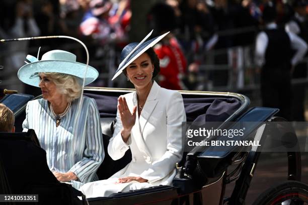 Britain's Catherine, Duchess of Cambridge , flanked by Britain's Camilla, Duchess of Cornwall , waves to the public as she arrives on a carriage to...