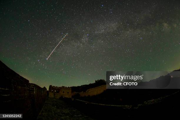 Meteors in the constellation Hercules streak over the Jinshanling Great Wall Scenic area in Luanping County, Chengde City, Hebei Province, in the...