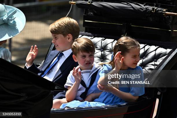 Britain's Prince George of Cambridge, Britain's Prince Louis of Cambridge and Britain's Princess Charlotte of Cambridge travel in a horse-drawn...