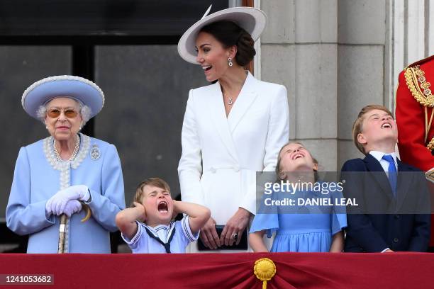Britain's Prince Louis of Cambridge holds his ears as he stands next to Britain's Queen Elizabeth II , his m mother Britain's Catherine, Duchess of...