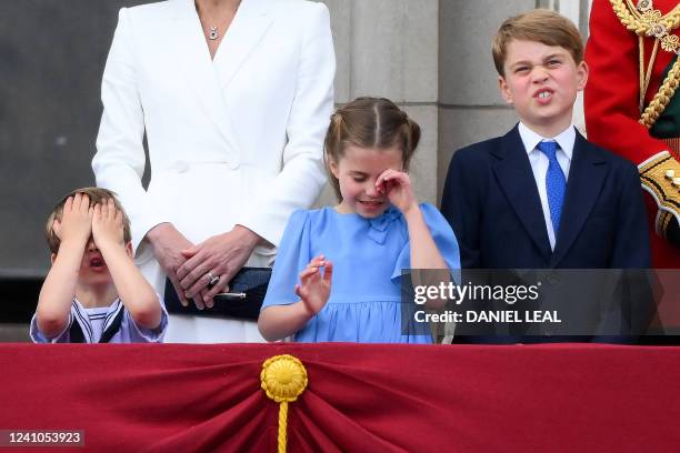 Britain's Prince Louis of Cambridge , Britain's Princess Charlotte of Cambridge and Britain's Prince George of Cambridge, react as they watch a...