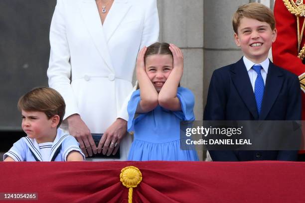 Britain's Princess Charlotte of Cambridge covers her ears as she stands with Britain's Prince Louis of Cambridge and Britain's Prince George of...