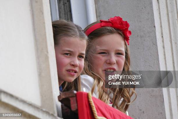 Britain's Princess Charlotte of Cambridge and Mia Grace Tindall watch from a window of Buckingham Palace as the troops march past during the Queen's...