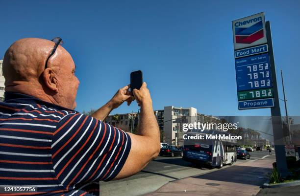 Jim Moreno of Los Angeles, takes a photograph of the sign, showing the price of gasoline approaching close to $8 a gallon at the Chevron gas station...