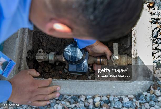Water flow restrictor device is installed on a water meter by Fernando Gonzalez, a Field Customer Service Representative with the Las Virgenes...