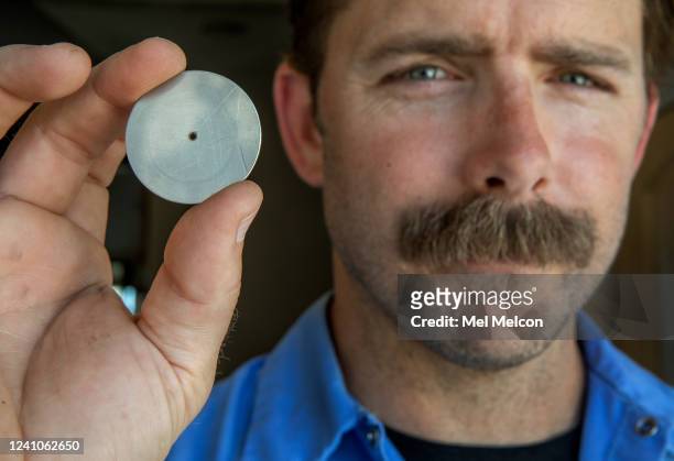 Cason Gilmer, a Senior Field Customer Service Representative for the Las Virgenes Municipal Water District, holds a water flow restrictor device that...