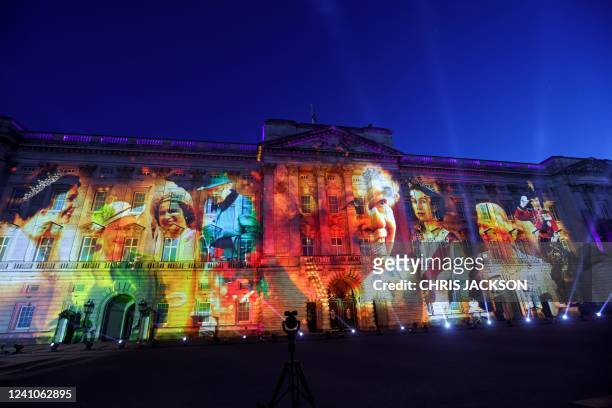 Projections are displayed on the front of Buckingham Palace depicting Queen Elizabeth II during The Lighting Of The Principal Beacon at Buckingham...