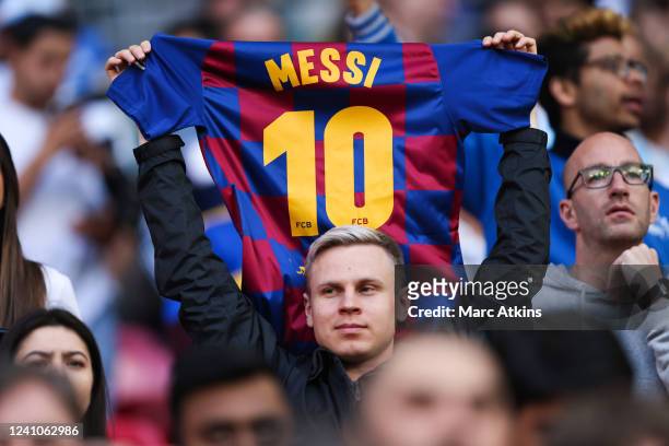 Fan holds an FC Barcelona short featuring the name of Lionel Messi during the Finalissima 2022 match between Italy and Argentina at Wembley Stadium...