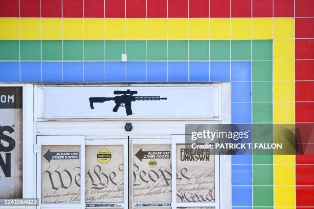 The silhouette AR-15 style rifle is displayed on signage for the Firearms Unknown Guns & Ammo gun store, in Yuma, Arizona on June 2, 2022. - US...