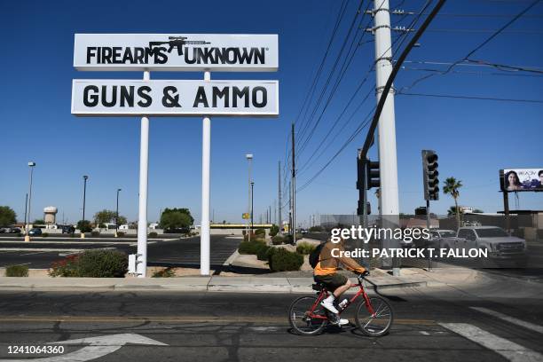 The silhouette AR-15 style rifle is displayed on signage for the Firearms Unknown Guns & Ammo gun store, in Yuma, Arizona on June 2, 2022. - US...