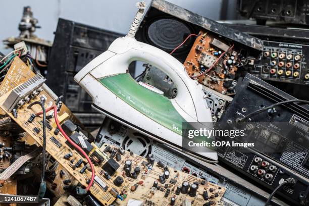 Broken electric iron box is seen amidst other electronic wastes at an e-waste collection center managed by Waste Electrical and Electronic Equipment...