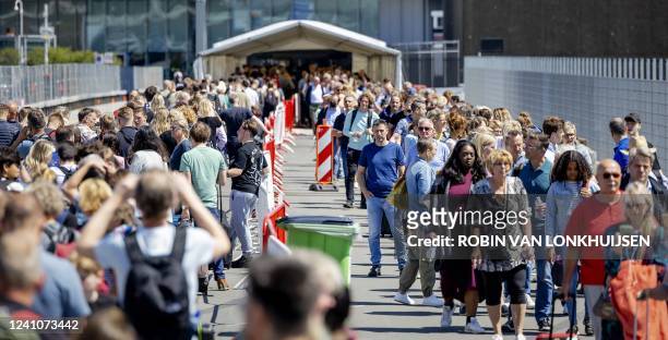 Travelers wait outside Schiphol airport on June 3, 2022. - Travelers are only allowed into the departure halls if their flight departs within four...