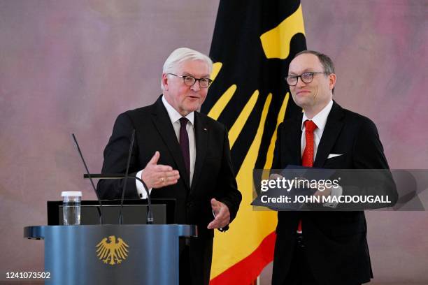 German President Frank-Walter Steinmeier gestures as outgoing judge of the German Federal Constitutional Court Andreas L Paulus holds his certificate...