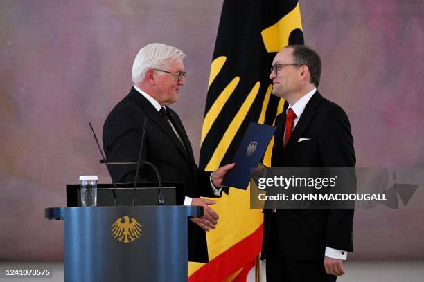 German President Frank-Walter Steinmeier hands the certificate of dismissal to outgoing judge of the German Federal Constitutional Court Andreas L...