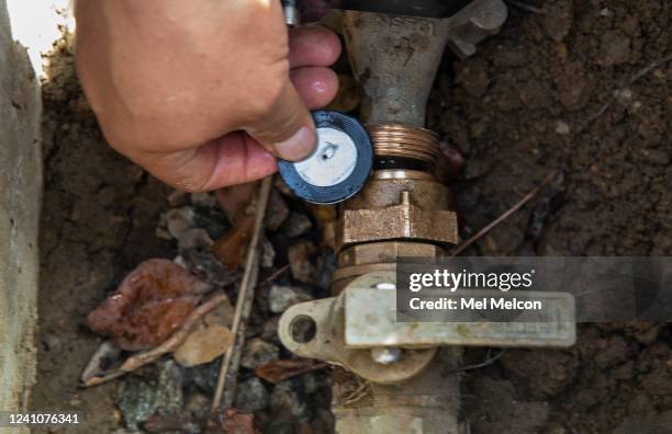 Fernando Gonzalez, a Field Customer Service Representative with the Las Virgenes Municipal Water District, displays a water flow restrictor device...