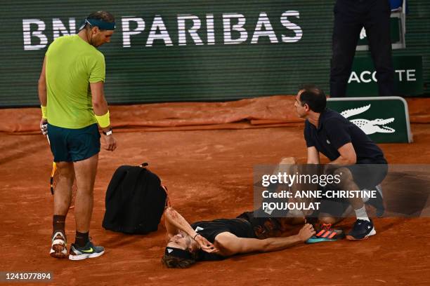 Germany's Alexander Zverev is assisted as he lies on court after being injured during his men's semi-final singles match against Spain's Rafael Nadal...