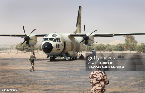 French soldiers from the Barkhane force and Chadian soldiers prepare to board a Chadian national army CJ27 Spartan transport plane at Faya-Largeau...