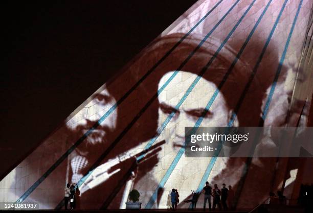 Iran's Azadi tower is illuminated with pictures of the late supreme leader Ayatollah Ruhollah Khomeini, to mark the 33rd anniversary of his death, in...