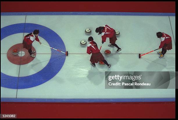 TEAM MEMBERS FROM JAPAN CLEAR A PATH FOR THE CURLING STONE DURING THEIR CURLING MATCH AGAINST GREAT BRITAIN AT THE 1992 WINTER OLYMPICS IN...