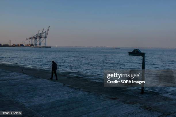 Man walks at dusk by the waterfront. The third largest city in Ukraine located in the south of the country, Odessa is the main naval base of the...