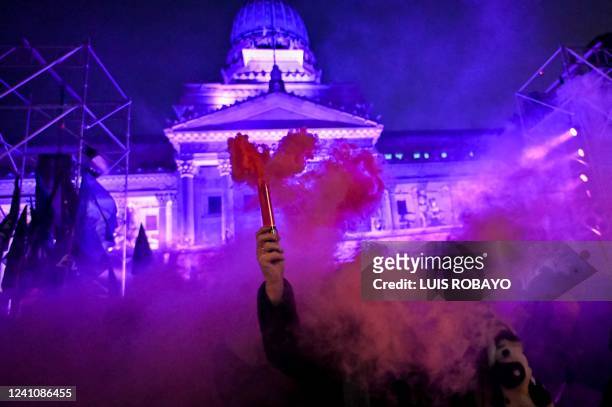 Women light bengals during the "Not One Less" demo against feminicide outside the Congress building in Buenos Aires, on June 3, 2022.