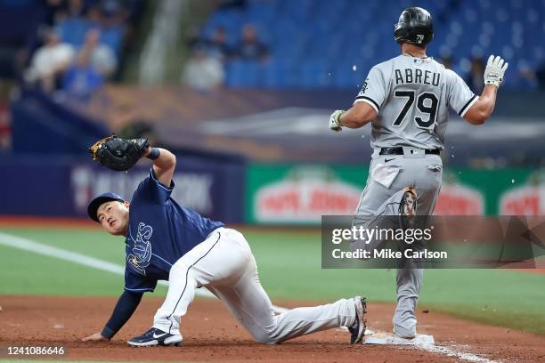 Ji-Man Choi of the Tampa Bay Rays checks his glove after scooping up a throw to first base to force out Jose Abreu of the Chicago White Sox during...