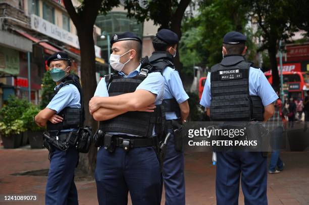 Police stand guard in the Causeway Bay district of Hong Kong on June 4, 2022 near the venue where Hong Kong people traditionally gather annually to...