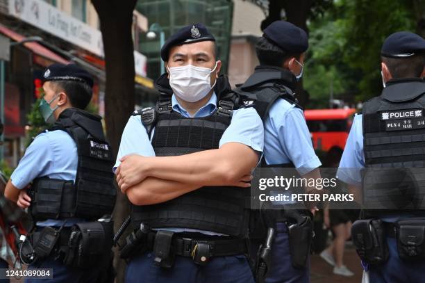 Police stand guard in the Causeway Bay district of Hong Kong on June 4, 2022 near the venue where Hong Kong people traditionally gather annually to...