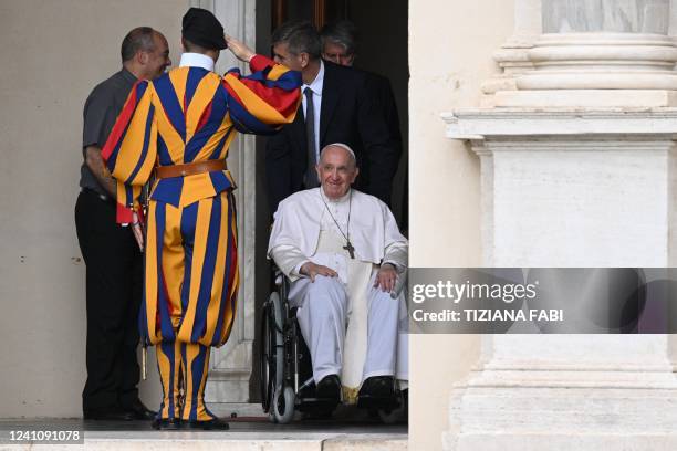 Swiss Guard salutes Pope Francis as he arrives, seated in a wheelchair following knee treatment, to preside over "The Cortile dei Bambini" meeting...