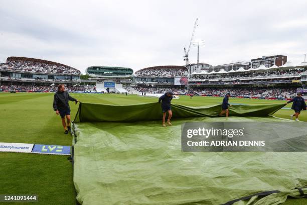 Groundstaff remove rain covers from the pitch ahead of start of play on the third day of the first cricket Test match between England and New Zealand...