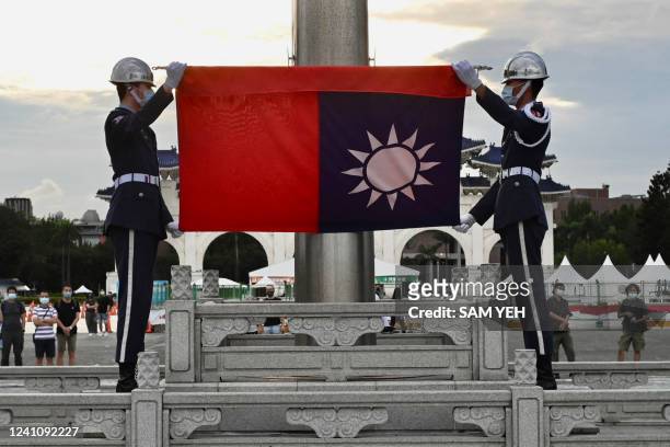 Honour guards fold the Taiwan flag during a flag lowering ceremony at the Chiang Kai-shek Memorial Hall in Taipei on June 4, 2022.