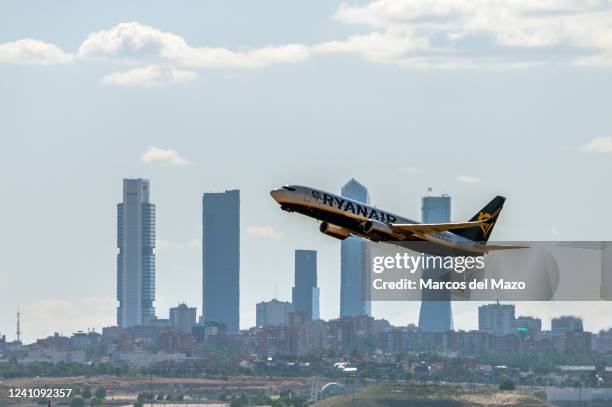 Ryanair airplane takes off from Madrid Adolfo Suarez Airport passing by the skyscrapers of the business area of Madrid.