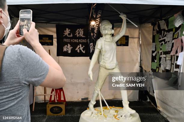 Visitor takes photos of a statue honouring demonstrators who took part in the 2019 Hong Kong pro-democracy protests, during a vigil on the 33rd...