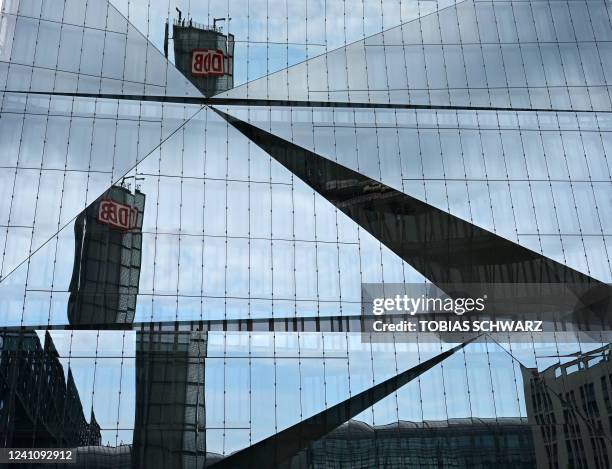 The building of Berlin Central Station with the logo of German rail operator Deutsche Bahn is reflected on the faceted glass facade of the 3XN Cube...