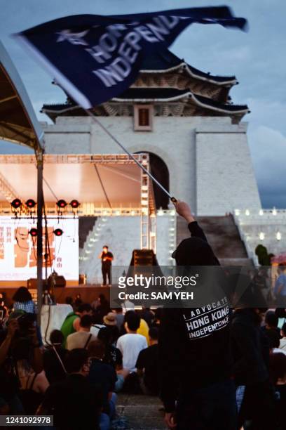 An activist waves a pro-democracy Hong Kong flag during a vigil on the 33rd anniversary of the 1989 Tiananmen Square pro-democracy protests and...