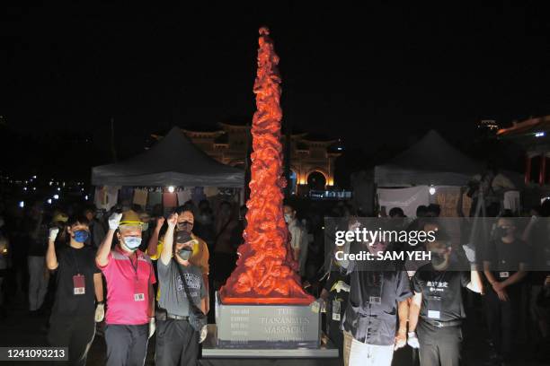 People chant slogans next to a "Pillar of Shame" during a vigil on the 33rd anniversary of the 1989 Tiananmen Square pro-democracy protests and...