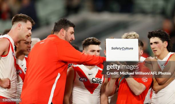 Dean Cox, Game Strategy & Ruck Coach of the Swans instructs players on a laptop during the 2022 AFL Round 12 match between the Melbourne Demons and...