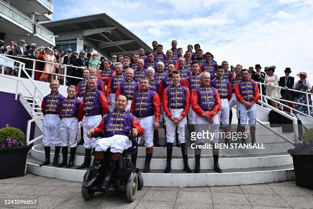 Collection of jockeys, past and present, who have ridden for Britain's Queen Elizabeth II, pose for a photograph, all wearing her silks on the second...