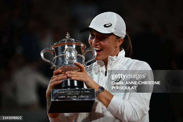 Poland's Iga Swiatek poses with the trophy after winning against US' Coco Gauff at the end of their women's single final match on day fourteen of the...